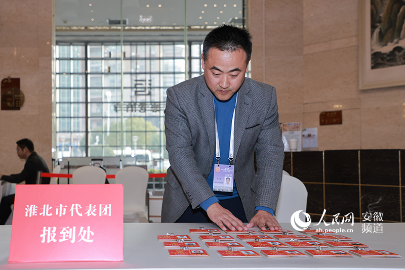 工作人员正在将证件摆放好，等待人大代表前来领取。人民网记者 王晓飞摄